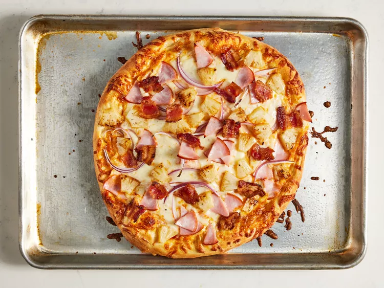 A hawaiian pizza on a plate
